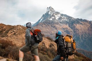 Life Happens Outdoors team leader Bader trekking to High Camp with renowned mountaineer Yeti Lakpa, with Fishtail Mountain in the background on the Mardi Himal Base Camp trek
