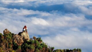 Life Happens Outdoors climber watches the sunset over a sea of clouds from the Mount Kilimanjaro trail during the trek.