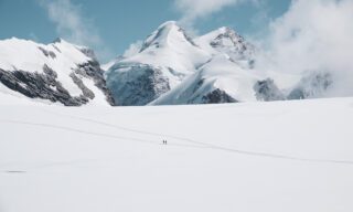 The Life Happens Outdoors team crossing the glacier plateau from the Klein Matterhorn (Petit Cervin) to the Breithorn, the first 4,000-meter summit of the Spaghetti Tour, with the Pollux and Castor summits in the background during the Spaghetti Tour Expedition Climb Monte Rosa.