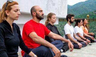 Life Happens Outdoors team in guided meditation at a Punakha monastery after a trek through Bhutan’s rice paddies during a Bhutan adventure tour