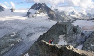 LHOers Ray Yafi and Catherine Choy above the Cabane des Vignettes, enjoying the spectacular view over the Arolla Valley and the Col de l'Évêque during the Chamonix to Zermatt Haute Route Expedition with the Life Happens Outdoors team.
