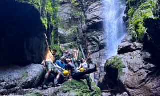 LHO adventurers canyoning through a river gorge in the Amazon, navigating waterfalls and rocky terrain deep in the rainforest.