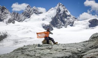 The LHO flag being raised on the Otemma Glacier during the Chamonix to Zermatt Haute Route Expedition with the Life Happens Outdoors team.