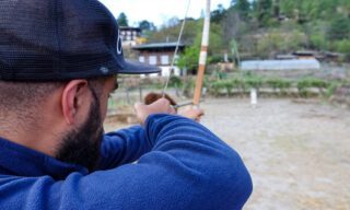 Life Happens Outdoors adventurer taking aim during a traditional Bhutanese archery session on a Bhutan adventure tour