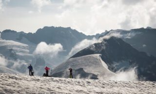 The Life Happens Outdoors team at the Col de l'Évêque with the Col des Bouquetins and the Dent d'Hérens in the background during the Chamonix to Zermatt Haute Route Expedition with the Life Happens Outdoors team.