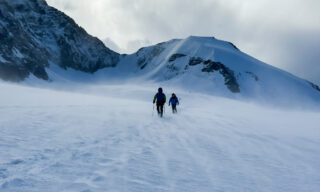 IFMGA guide Philippe Genin retreating from the Naso del Lyskamm during bad weather and seeking a different route around it to reach the Refugio Gnifetti during the Spaghetti Tour Expedition Climb Monte Rosa with the Life Happens Outdoors team.