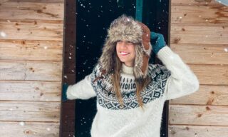 Ghida Arnaout, co-founder of Life Happens Outdoors, outside the fire hut during a dog sledding excursion on our Senja northern lights tour.