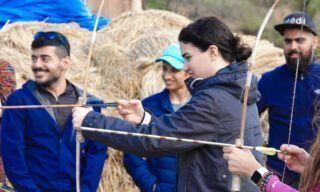 Life Happens Outdoors team learning Bhutanese archery, the national sport, during a cultural experience on a Bhutan adventure tour