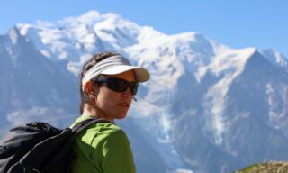 LHO guide Lucia Guichot Martin leading the Life Happens Outdoors team in Brévent with Mont Blanc towering in the background during the Tour du Mont Blanc (TMB).