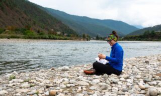 Life Happens Outdoors team member enjoying a riverside picnic in Punakha during a day of white water rafting on a Bhutan adventure tour