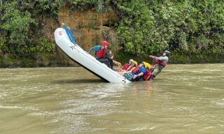 LHO adventurers rafting down a wild stretch of the Amazon River, surrounded by dense jungle and vibrant greenery.