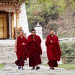 Monks walking through Punakha Dzong, a cultural highlight of Bhutan explored during the Life Happens Outdoors adventure tour
