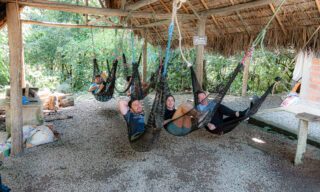 LHO adventurers relaxing on hammocks at a locally run rainforest lodge operated by indigenous communities, deep in the Ecuadorian jungle.