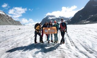 The LHO flag being held on the Otemma Glacier with LHO co-founder Ghida Arnaout and IFMGA guide Gregoire Sauget during the Chamonix to Zermatt Haute Route Expedition with the Life Happens Outdoors team.