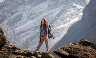 LHO Team Leader Menna Emad beneath Machapuchare (Fishtail Mountain) on her way to Annapurna Base Camp during the Annapurna Base Camp Trek with the Life Happens Outdoors team.