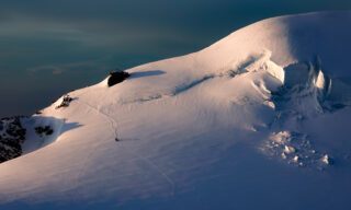 IFMGA guide Pavlos leading our team down from the summit of the Parrotspitze, as seen from Punta Gnifetti at sunrise, with the incredible Monte Rosa Glacier reflecting the alpenglow during the Spaghetti Tour Expedition Climb Monte Rosa with the Life Happens Outdoors team.
