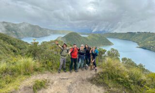 Scenic view of the turquoise crater lake near Quito, surrounded by the dramatic ridges of an Ecuadorian volcano.