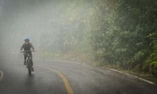LHO adventurers road biking down the slopes of Tungurahua Volcano above Baños, weaving through Ecuador’s cloud forest.