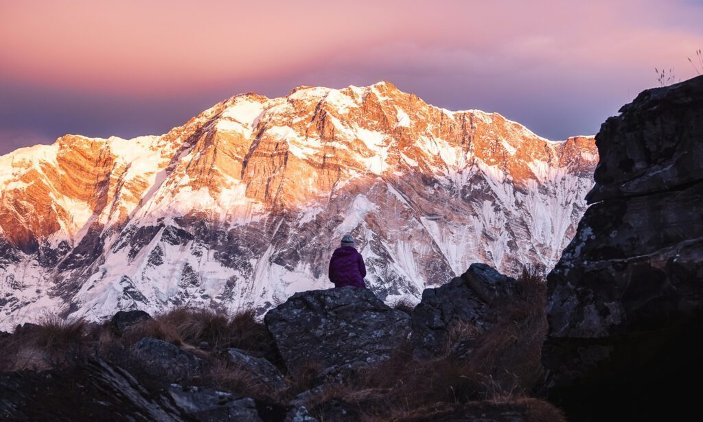 A lone trekker sits infront of the Annapurna Massif