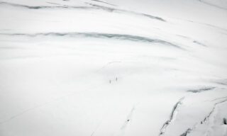 The Life Happens Outdoors team traversing the glacier beneath the Naso del Lyskamm on the way to Refugio Gnifetti during the Spaghetti Tour Expedition Climb Monte Rosa with the Life Happens Outdoors team.