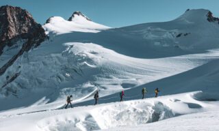 Crossing the crevasse of the Col de Lys on the way to the summit of Piramide Vincent and Balmenhorn during the Spaghetti Tour Expedition Climb Monte Rosa with the Life Happens Outdoors team.