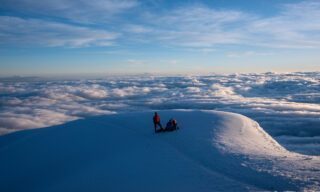 The Life Happens Outdoors team taking a break to watch the sunrise from the shoulder of Cotopaxi during the Climb Cotopaxi & Climb Chimborazo Expedition.