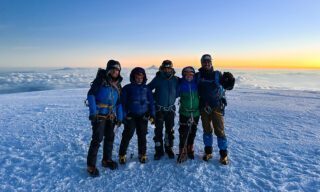 On the summit of Chimborazo at sunrise during the Climb Cotopaxi & Climb Chimborazo Expedition with the Life Happens Outdoors team.