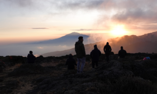 A.T. Kearney team at Shira Camp on Mount Kilimanjaro, watching an incredible sunset as part of their Life Happens Outdoors corporate climbing challenge.
