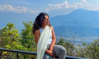 Life Happens Outdoors adventurer capturing a photo with the Annapurna range backdrop on the first day of trekking in clear blue sky weather