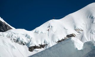 Summit ridge of Island Peak with LHO climbers navigating the final ascent during a perfect weather day.