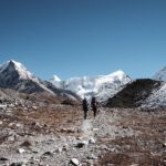 Climbers Roberto David and Haneen Alsliman trekking from Chukhung to Island Peak Base Camp, with the dramatic, free-standing face of Island Peak rising directly ahead.