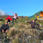 Life Happens Outdoors team relaxing outside Horombo Hut in the short grass vegetation zone during their Kilimanjaro descent.