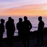 Life Happens Outdoors team at Shira Camp on Kilimanjaro, watching a vivid purple sunset above a sea of clouds on the Machame Route.