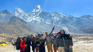The LHO team, including Team Leader Rami Rasamny, at Ama Dablam Base Camp before their ascent on the Climb Ama Dablam Expedition with Life Happens Outdoors, with the peak standing clear behind them in perfect conditions.