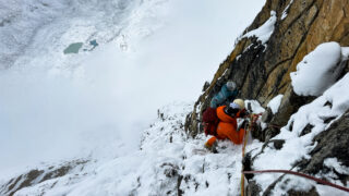 LHO climber Masha descending beneath the Yellow Tower in snowy conditions on the Climb Ama Dablam Expedition with Life Happens Outdoors.