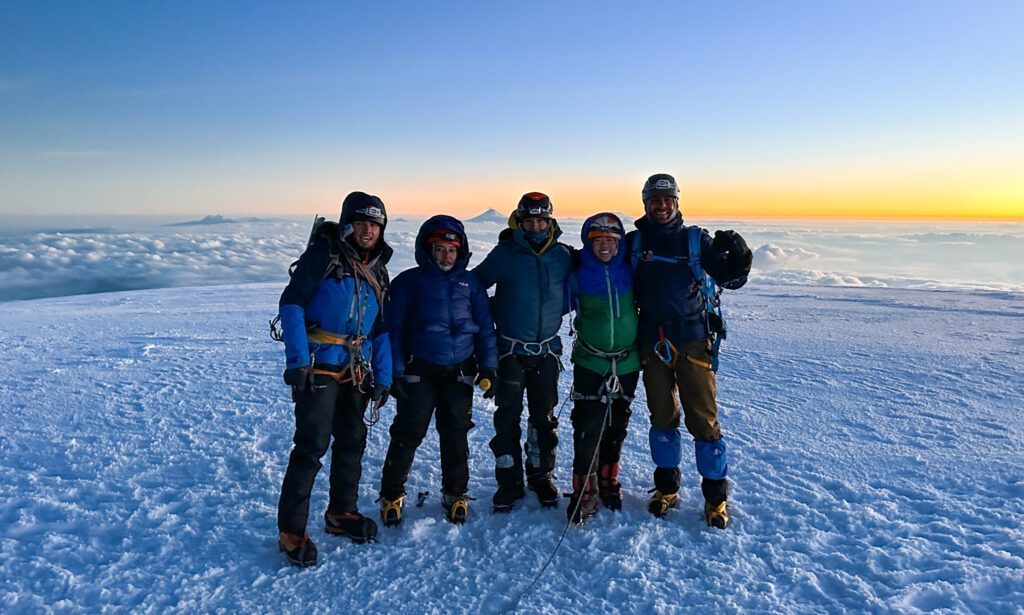 Sunrise on the summit of Chimborazo with Cotopaxi, Antisana, and Cayambe visible on the horizon during the Climb Cotopaxi & Climb Chimborazo Expedition with the Life Happens Outdoors team.