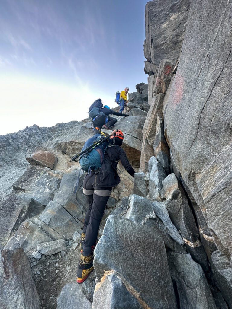 Climbing the rocks of the Grand Couloir beneath the Goûter Hut during the Mont Blanc Summit Climb course with the Life Happens Outdoors team.