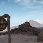 LHOer Edy Nasr standing on a rock at Kibo Hut with the Mawenzi Crater in the background on the Marangu Route during the Climb Kilimanjaro Expedition with the Life Happens Outdoors team.