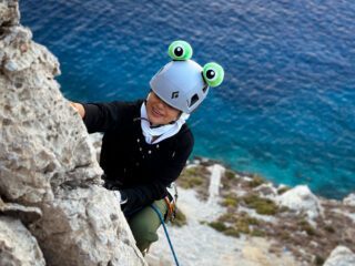 LHOer climbing in the Castelo crag above the sea during the Rock Climbing in Kalymnos adventure with the Life Happens Outdoors team.