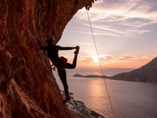 Climbing in the Grande Grotta at sunset during the Yoga and Rock Climbing in Kalymnos adventure with the Life Happens Outdoors team.
