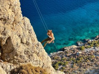 LHO Founder and Team Leader Ghida Arnaout climbing over the sea during the Rock Climbing in Kalymnos adventure with the Life Happens Outdoors team.