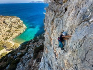 LHOer climbing over the sea on a remote beach only accessible by boat during the Rock Climbing in Kalymnos adventure with the Life Happens Outdoors team.