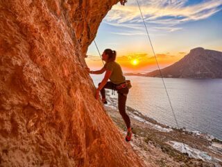 Climbing in the Grande Grotta with incredible sunset light and the sea in the background during the Rock Climbing in Kalymnos adventure with the Life Happens Outdoors team.