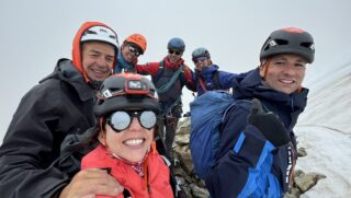 Nelly Attar on the summit of the Eiger after completing the Mittellegi Ridge with the LHO team, guided by IFMGA guide François Xavier during the Climb the Eiger Course.