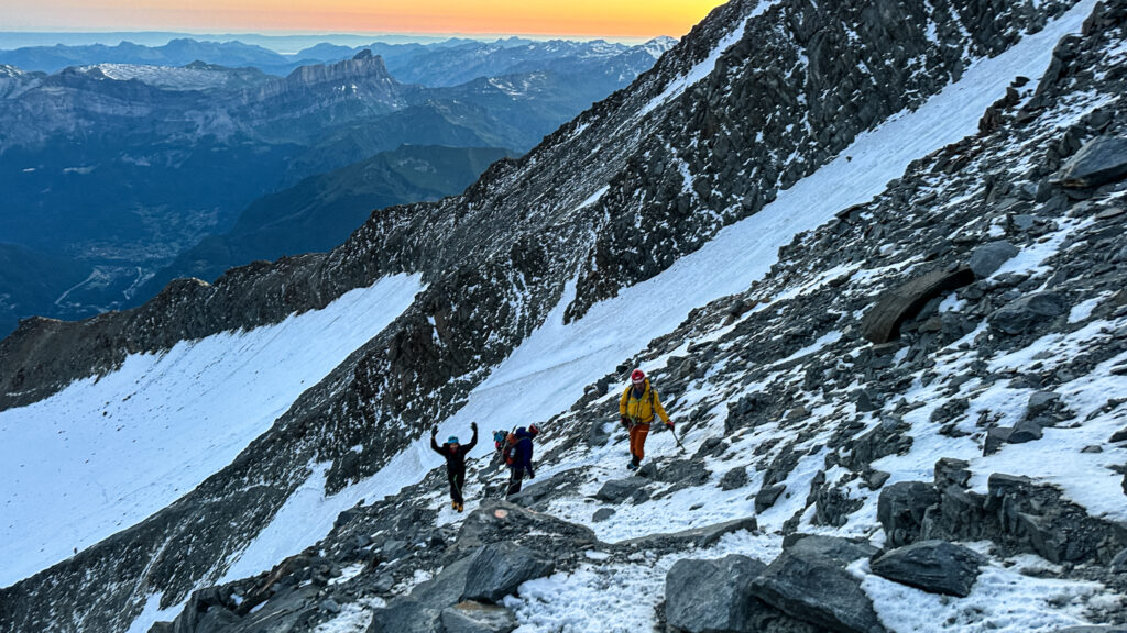 LHOers Hannah Piercy and Gino Traboulsi being led by LHO IFMGA mountain guide Pavlos Tsiantos across the Grand Couloir during the summit push of Mont Blanc with the Life Happens Outdoors team.