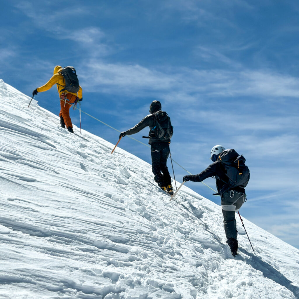 LHOers Hannah Piercy and Gino Traboulsi being led by LHO IFMGA mountain guide Pavlos Tsiantos on the first mogul during the summit push of Mont Blanc with the Life Happens Outdoors team.