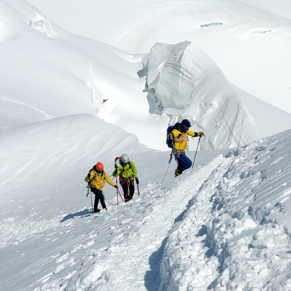 Climbing Mont Blanc with the Life Happens Outdoors team on the summit ridge, surrounded by dramatic glaciers and alpine scenery.