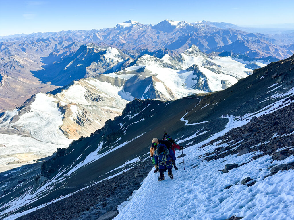 Hari Budha Magar, Abiral Rai, and Mingma Phortse Sherpa on the traverse of Aconcagua with the incredible Andes range now in the sunshine, perfect weather, and no wind during the Aconcagua Expedition with the Life Happens Outdoors team.