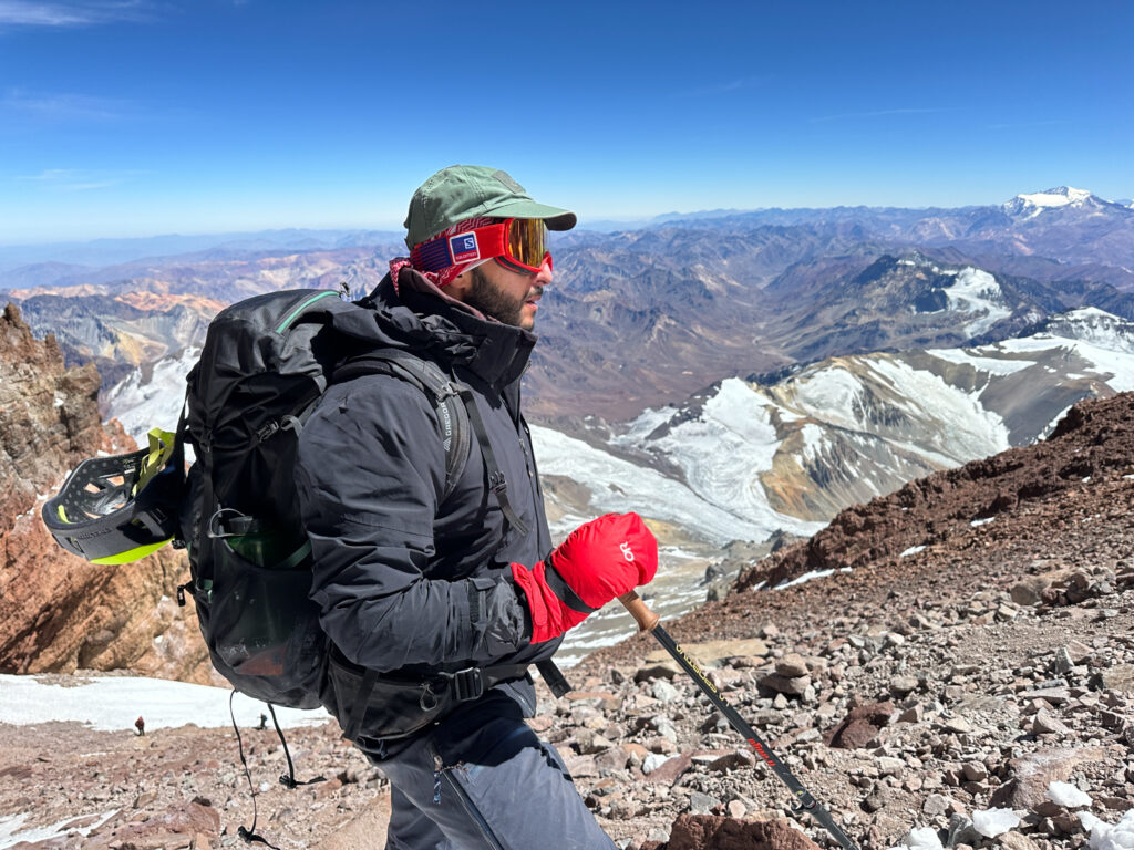 Khalil Chehab just beneath the summit of Aconcagua with the incredible view across the Andes in the background during the Aconcagua Expedition with the Life Happens Outdoors team.