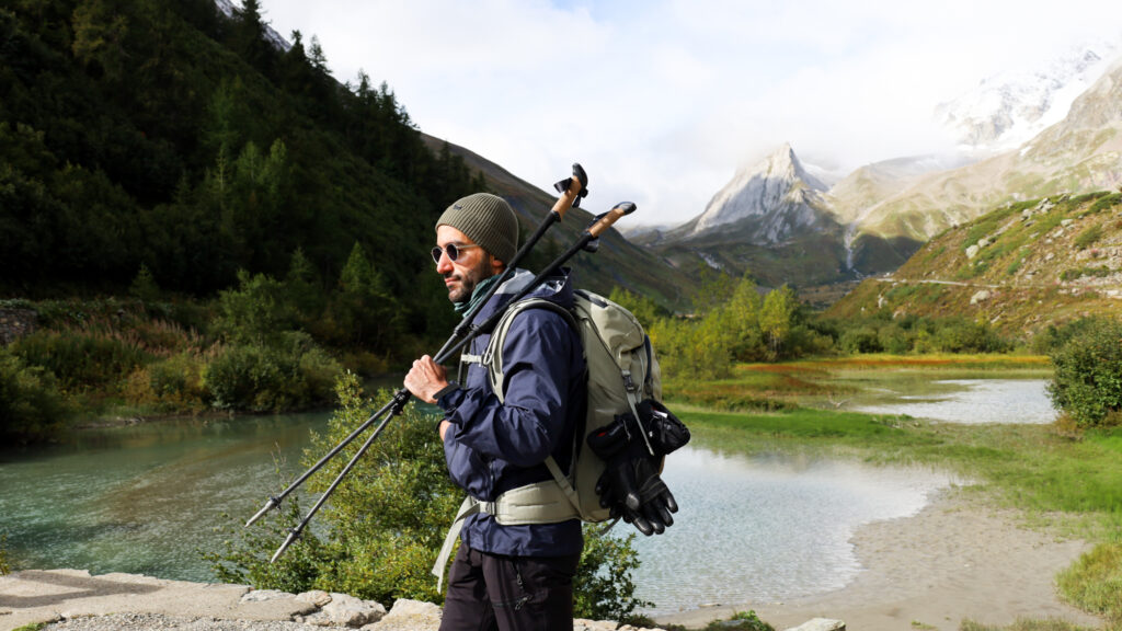 LHO team member at the entrance of Val Veny with alpine lakes in the background, approaching Col de la Seigne on the Tour du Mont Blanc hike between Italy and France.